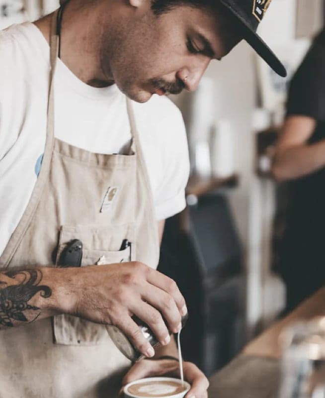 A barista carefully doing coffee art